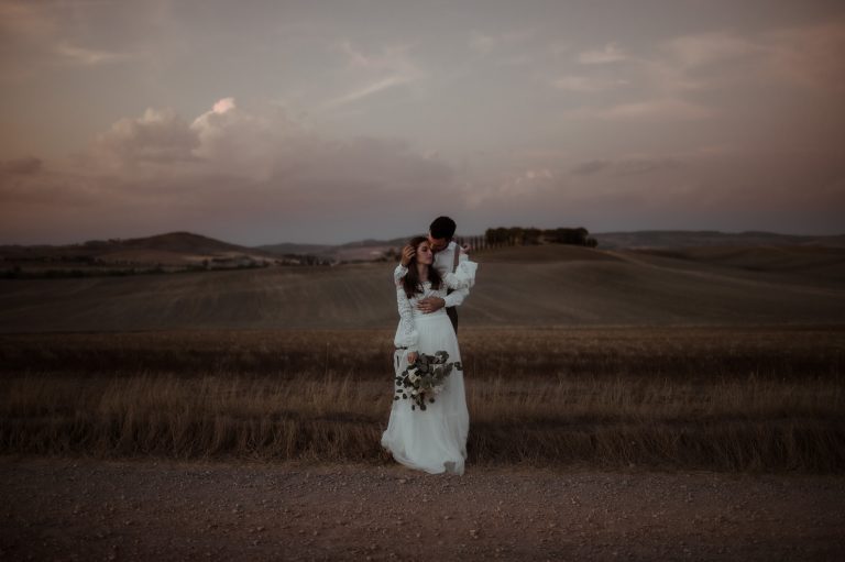 Tuscany Elopement Wedding | Bride and groom in a field at sunset at Pienza in Val d'Orcia