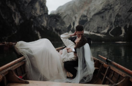 Groom kissing bride on the boat during Lake Braies Elopement in the Dolomites