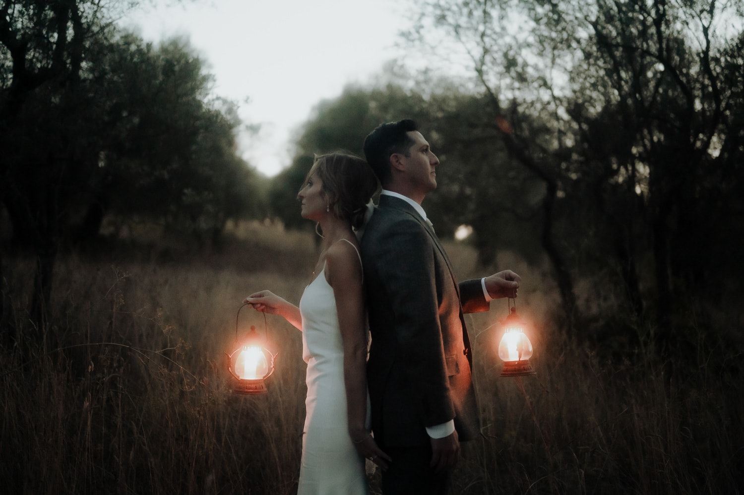 Bride and groom facing two different directions with lanterns in Tuscany during Italy Elopement