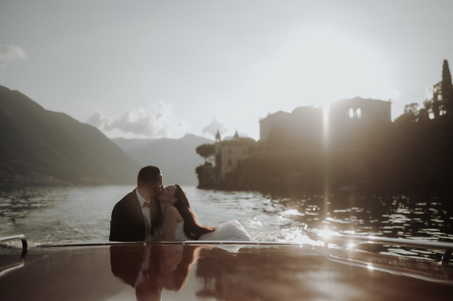 Bride and groom kissing on a boat during Lake Como Wedding