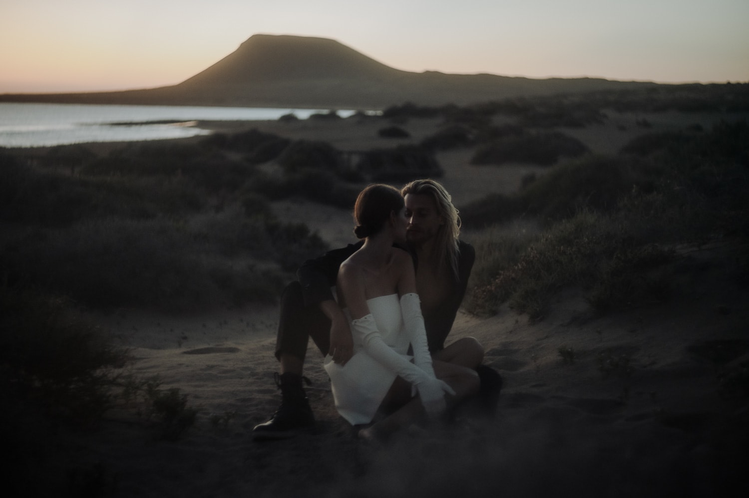 Bride and groom sitting on the desert of LA Graciosa during Lanzarote Elopement